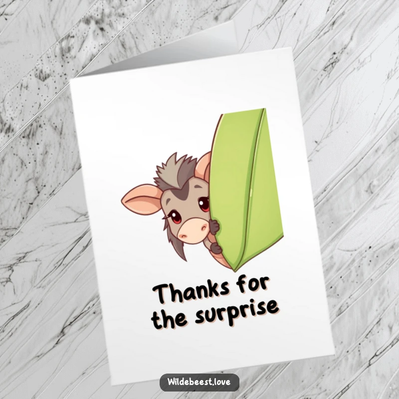 Funny free printable thank you card: a happy wildebeest peeks from behind a leaf, offering a shy thank you.